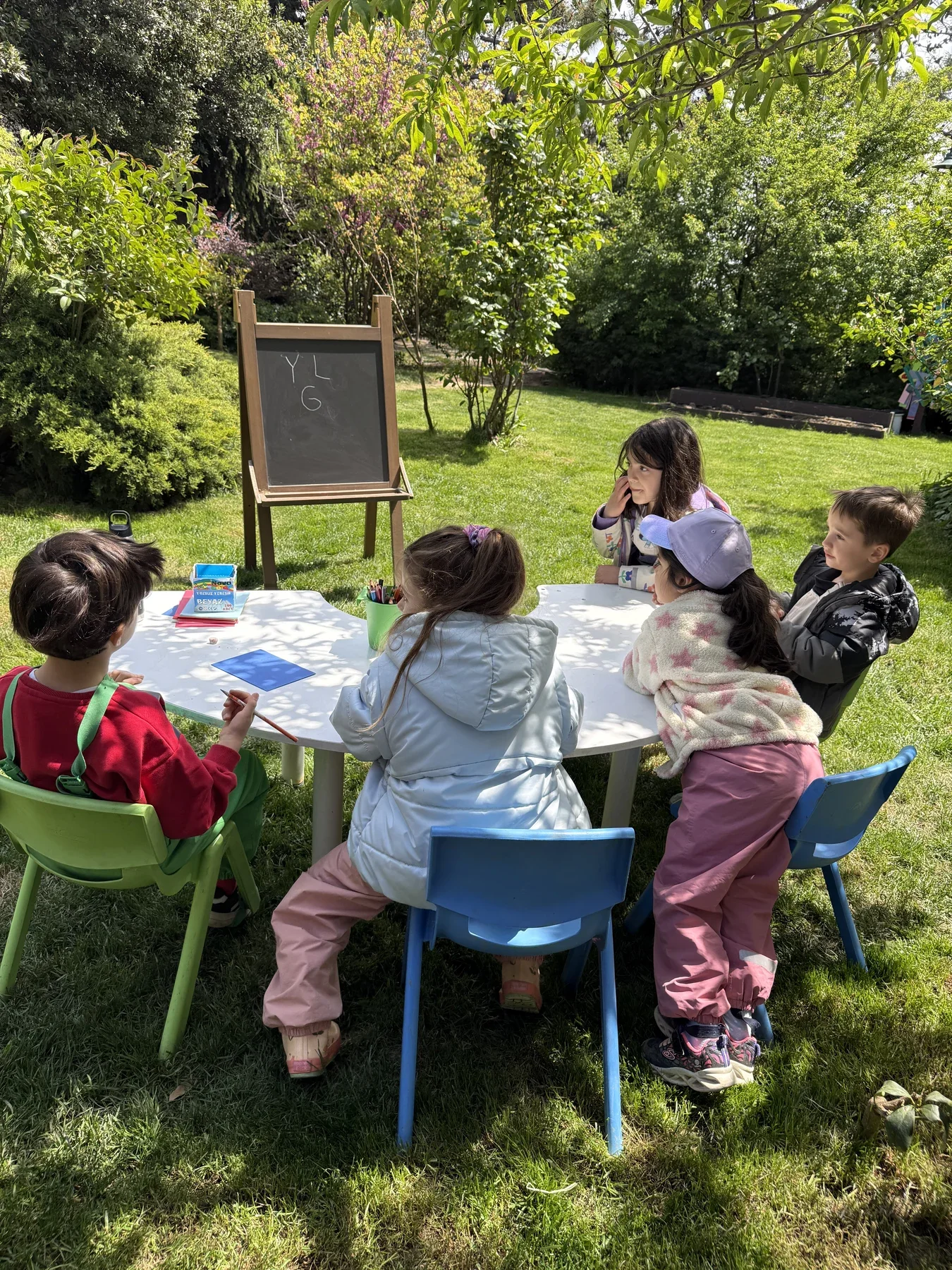 Bahçede canlılarla etkileşim kuran çocuk